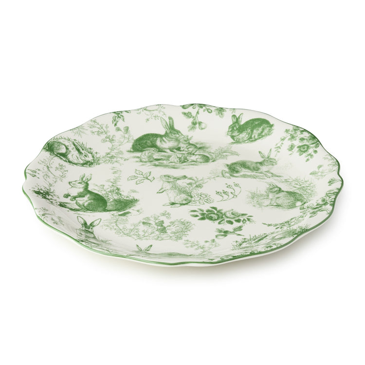 Round ceramic platter with scalloped rim featuring delicate green French garden artwork on a white background.