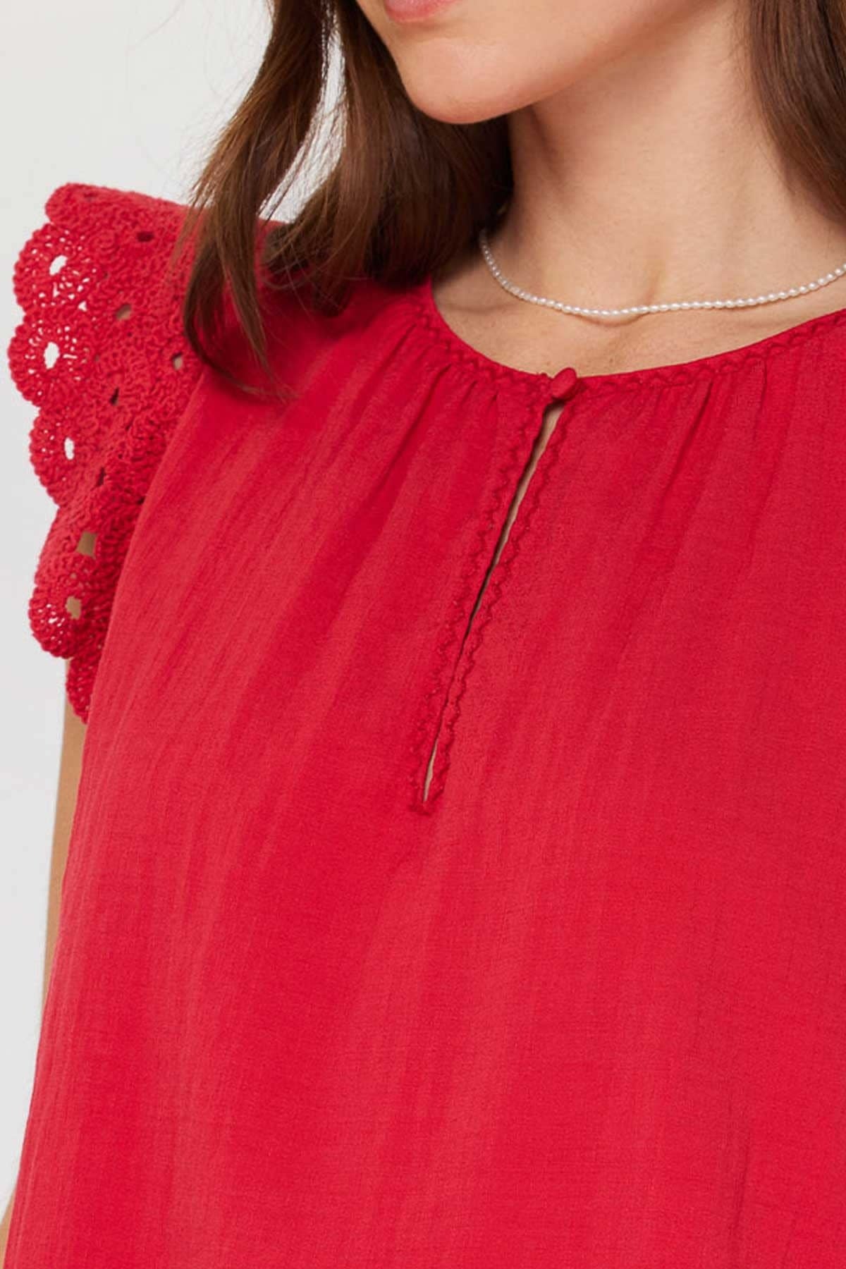Red round-neck crochet blouse with short sleeves, front buttons, and a keyhole neckline detail.