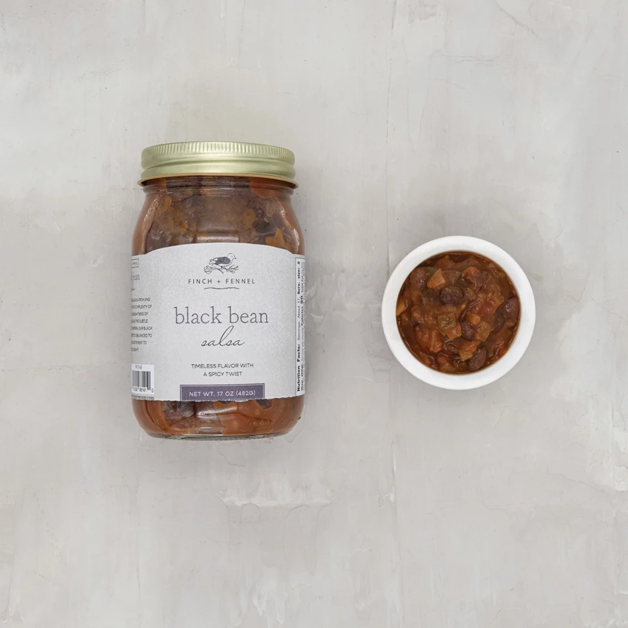 Open jar of black bean salsa with visible beans in red sauce