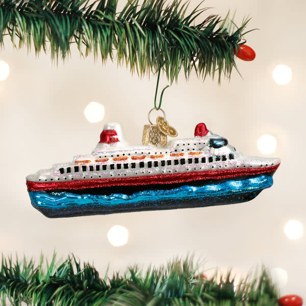 Red cruise ship ornament with white sails standing on a gold stand.