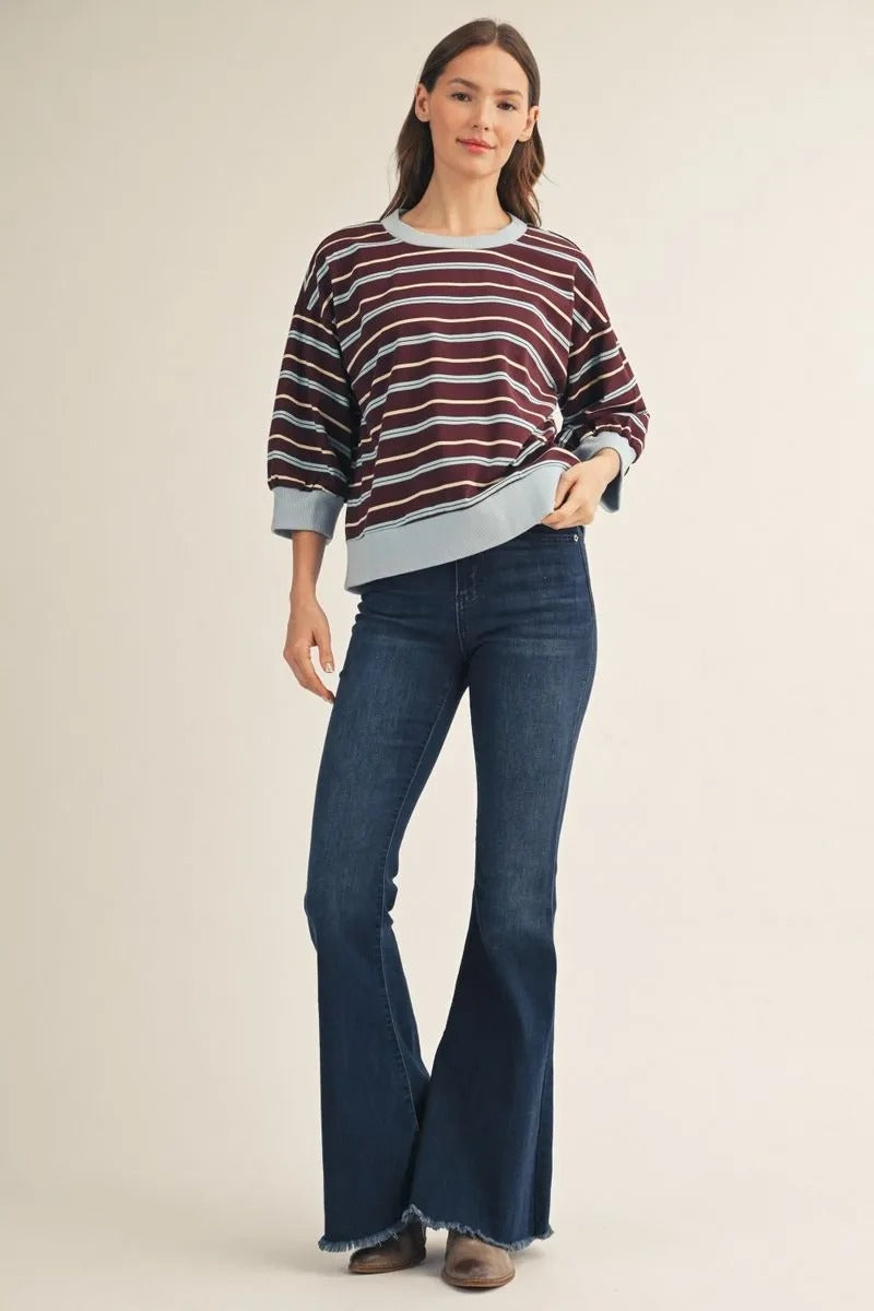 Woman wearing the Ava 3/4 Sleeves Casual Stripe Top in burgundy and blue with flare jeans.