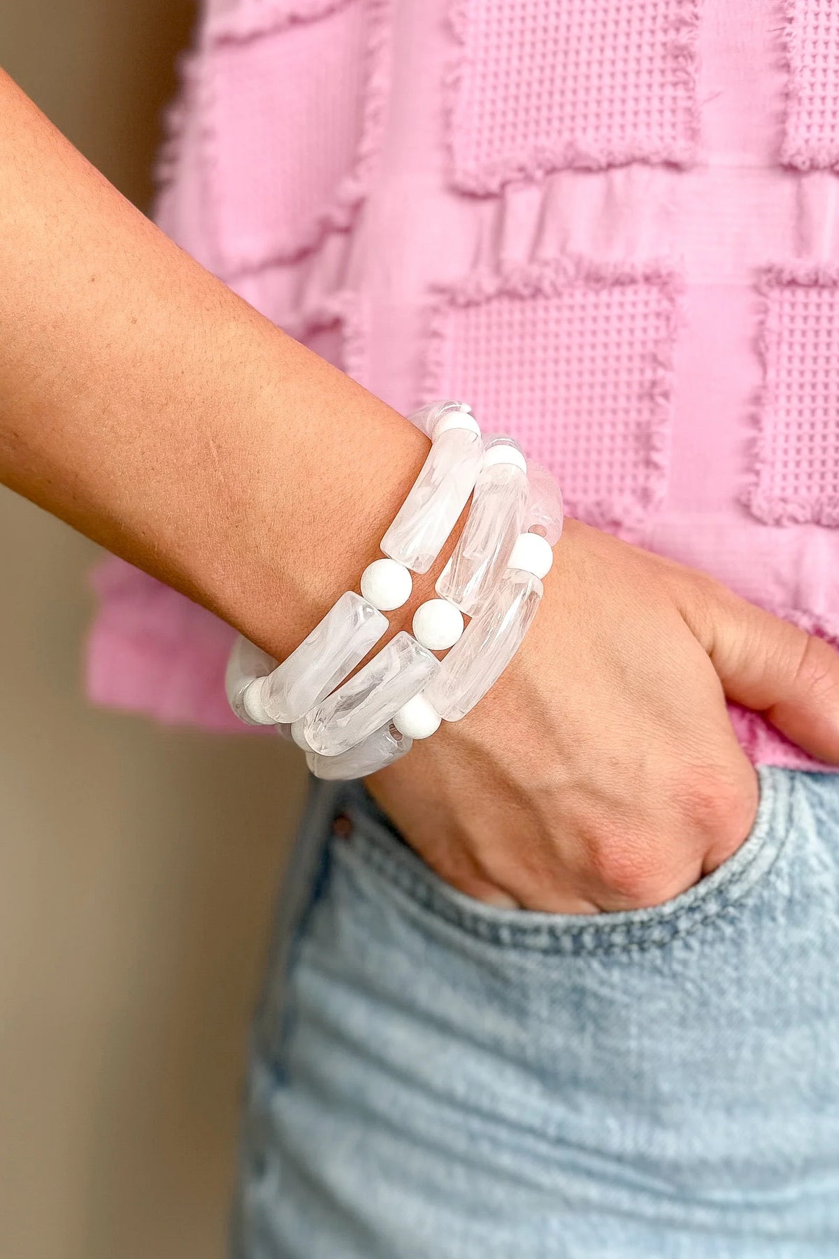 A stack of three WS Emmy Bracelets with white marble-effect tubes and solid white beads.