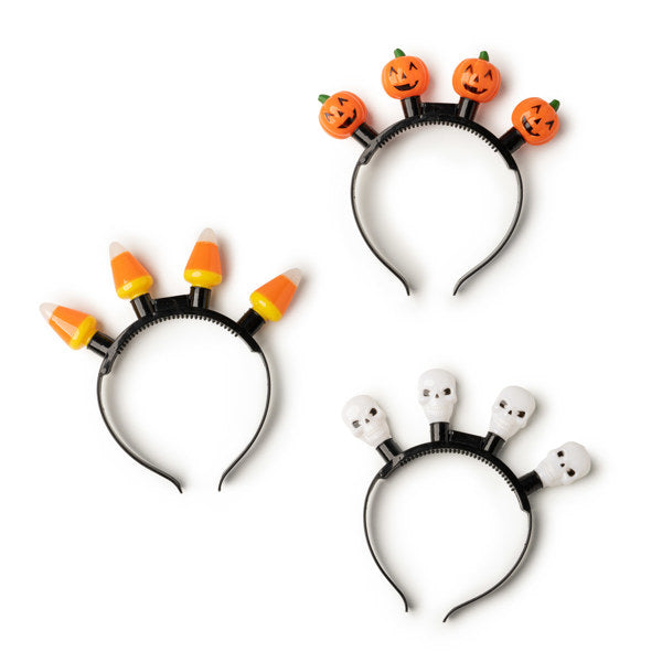 Three Halloween jumbo light up headbands featuring orange pumpkins, candy corn, and white skulls.