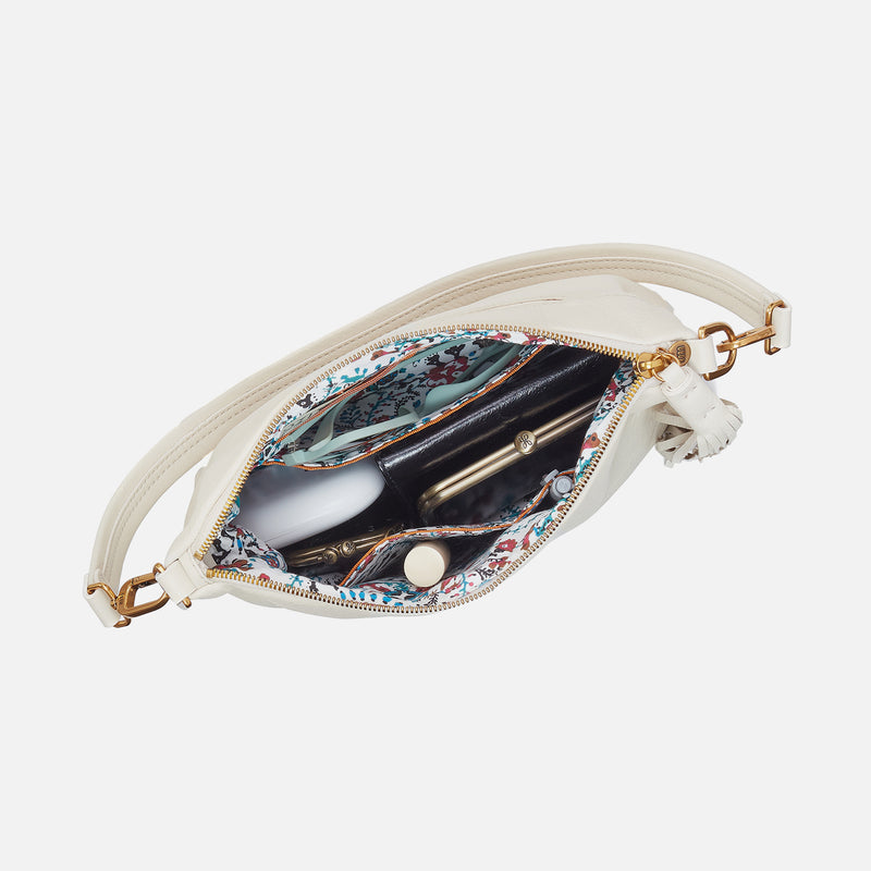 Kori crossbody bag in Old English Brass hardware with Sandlewood lining featuring zip and slip pockets.
