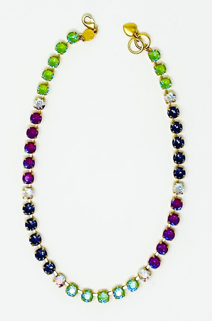 Gold chain necklace featuring a gradient of multi-colored round crystals in a classic tennis style.