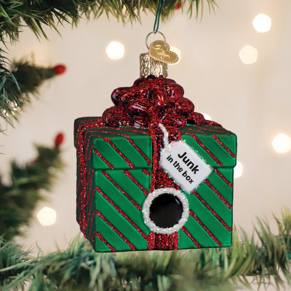 Green glass "Junk in the Box" Christmas ornament with red glitter stripes and a black center.