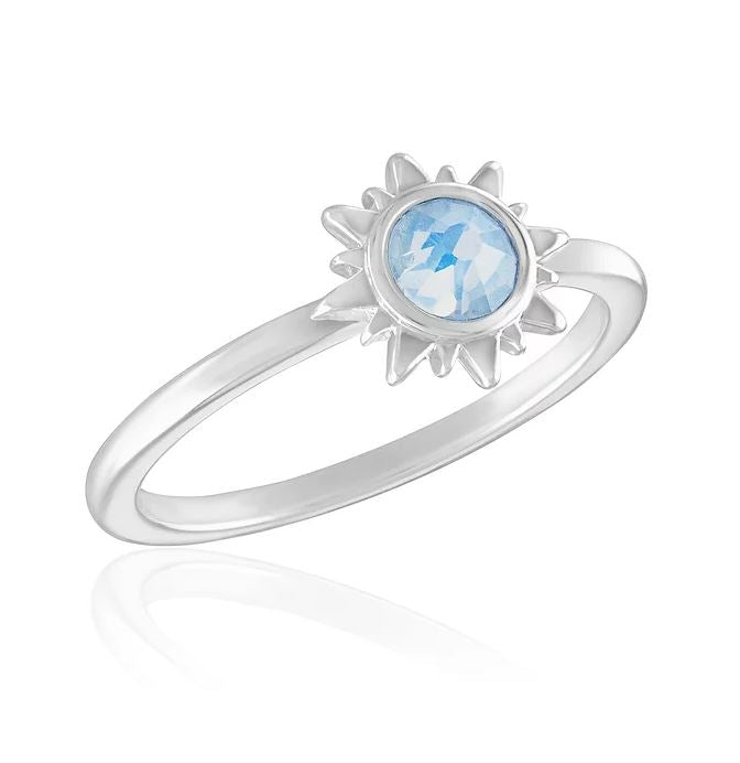Silver stackable ring featuring a sunburst design set with a round light blue gemstone.