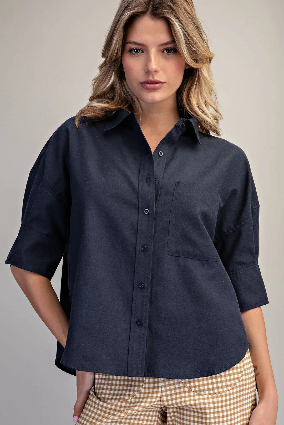 Woman wearing a navy blue Lou Button Down Short Sleeve Shirt with a chest pocket and relaxed fit.