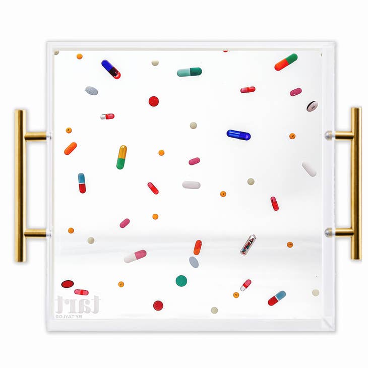 Square acrylic tray with gold handles featuring a colorful pill and capsule pattern.