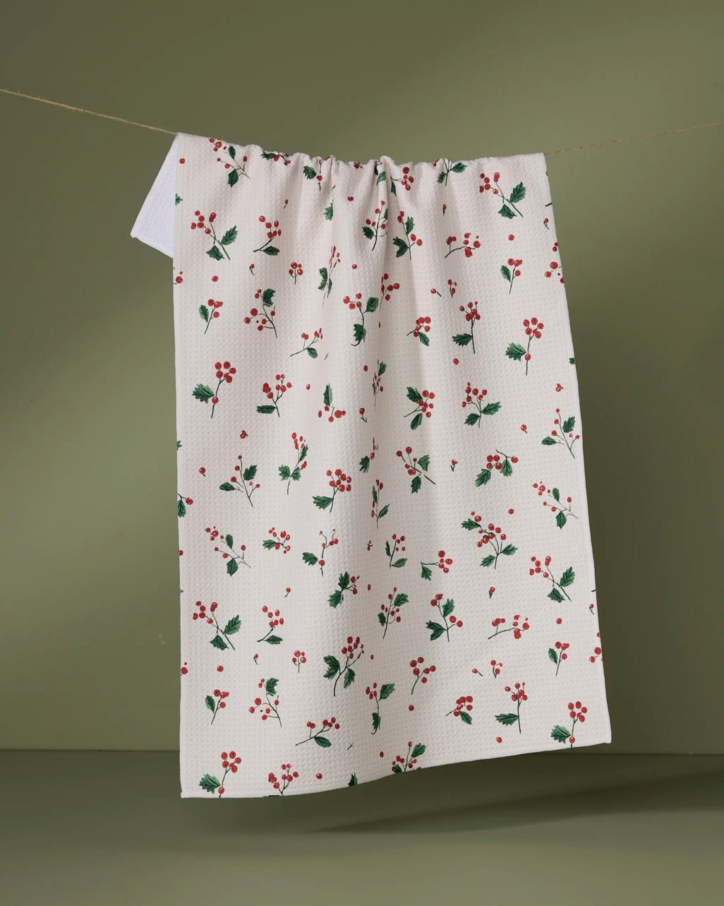 Holiday tea towel with waffle weave construction in red featuring a festive snowman pattern.