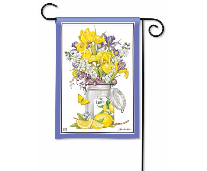 Garden flag with a bouquet of yellow and purple irises in a glass jar with lemons and a butterfly.