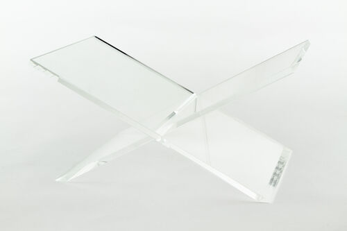 Clear acrylic book stand with a modern geometric cutout base.