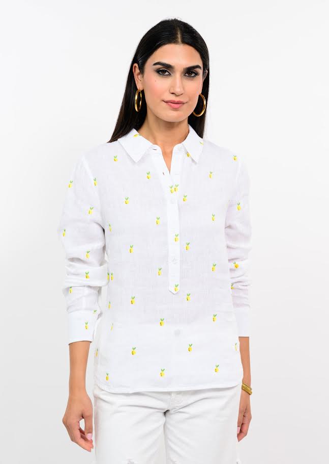 Woman wearing a white long-sleeve linen shirt with small embroidered yellow lemons.