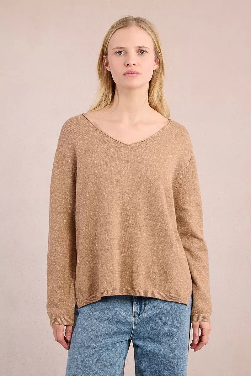 Woman wearing a Lesli Ladies Knitted Sweater in camel brown with a V-neckline and blue jeans.