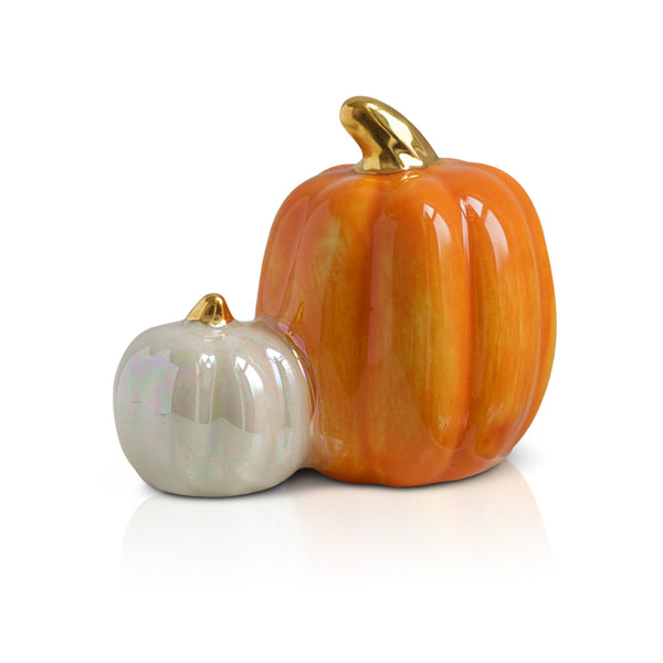 Two ceramic pumpkins, one orange and one pearlescent white, with gold stems.