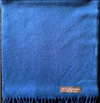 Blue cashmere scarf with fringe and a small tag featuring a Union Jack.