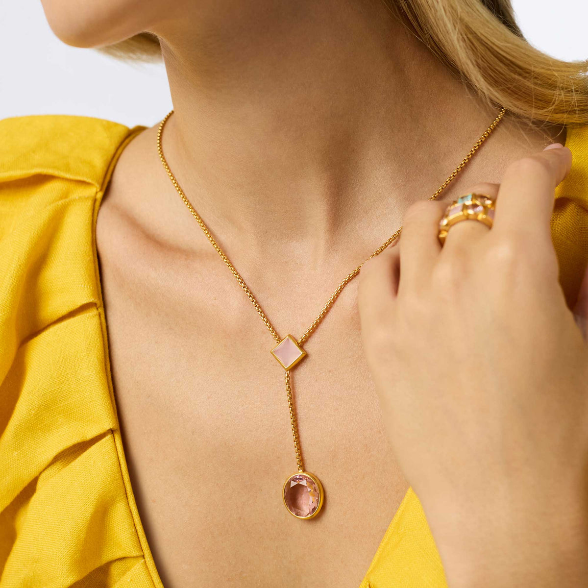 Adjustable lariat necklace with a long pendant chain in gold-tone finish featuring an imported glass stone.