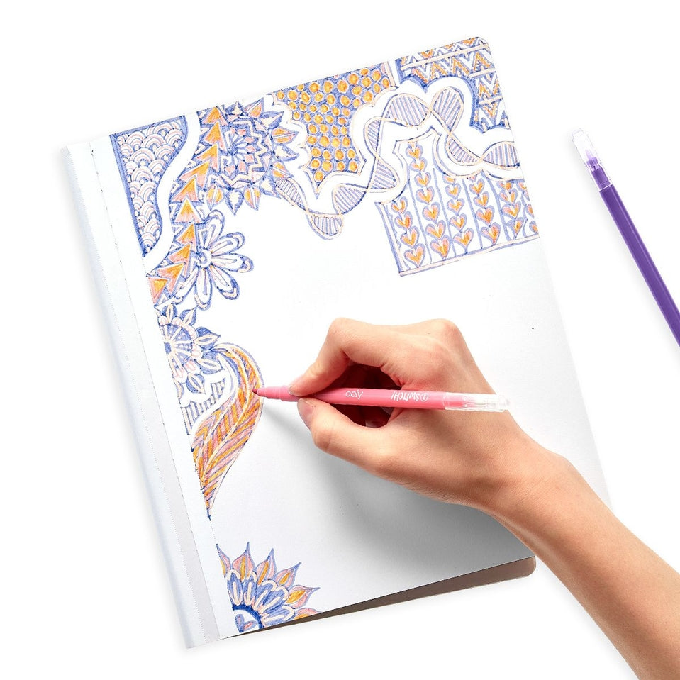 Hand drawing a colorful pattern in a notebook using a pink Switch-eroo color-changing marker.