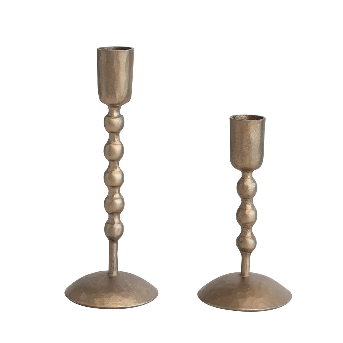 Set of two hand-forged iron taper candle holders with a beaded stem and antique brass finish.