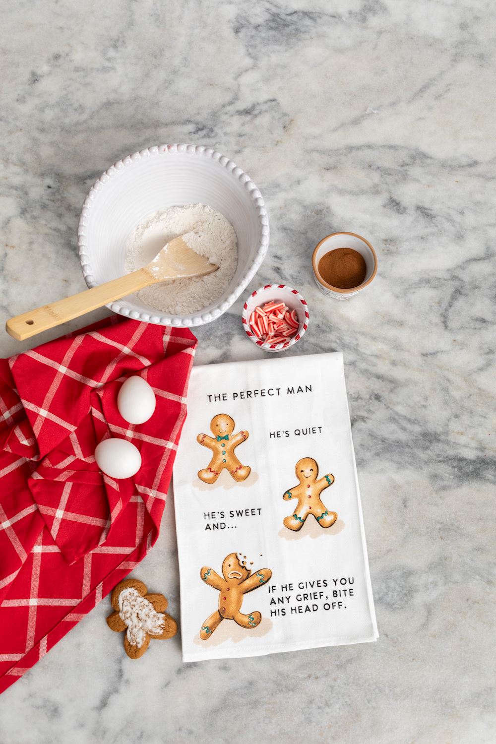 White kitchen towel with gingerbread man graphic and humorous text about the perfect man.