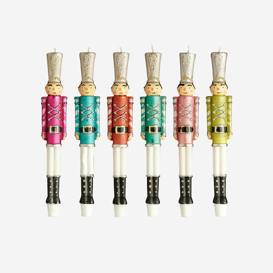 Six colorful nutcracker soldier candles in pink, blue, red, green, light pink, and lime green.