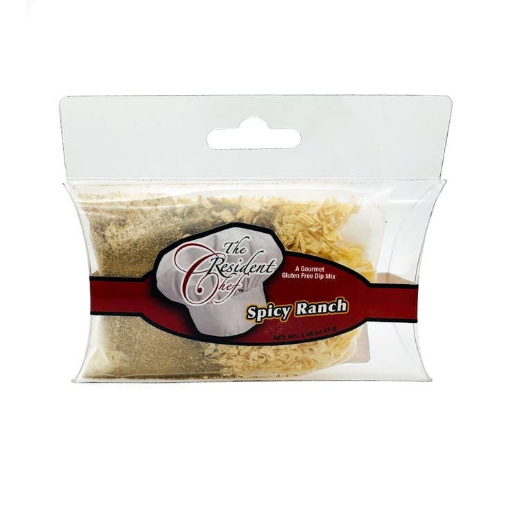 Front view of a Spicy Ranch Dip Mix packet with red and green seasoning visible through clear plastic packaging.