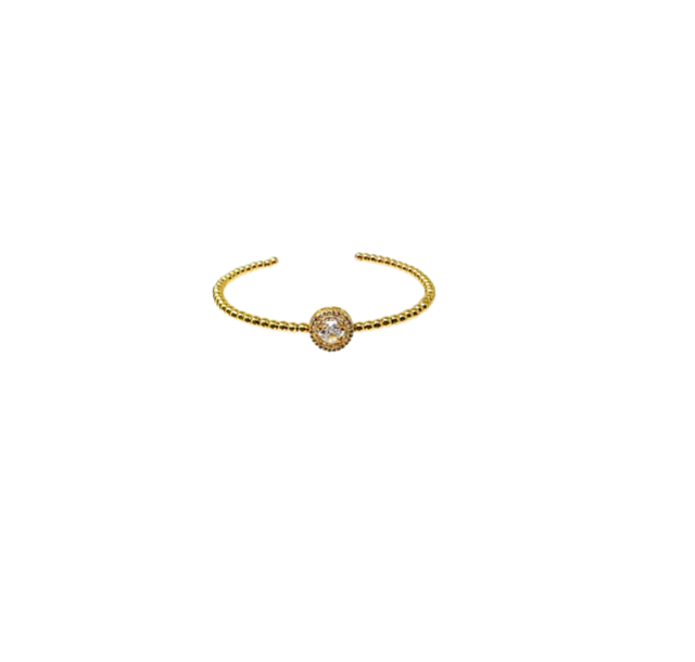 Gold beaded cuff bracelet with a central round cubic zirconia stone in a textured setting.