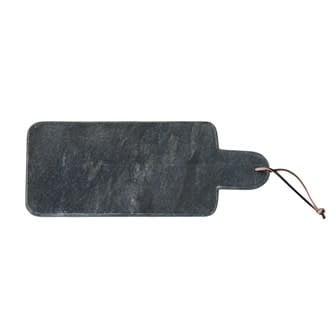 Black marble cutting board with a leather hanging strap displayed on a shelf.