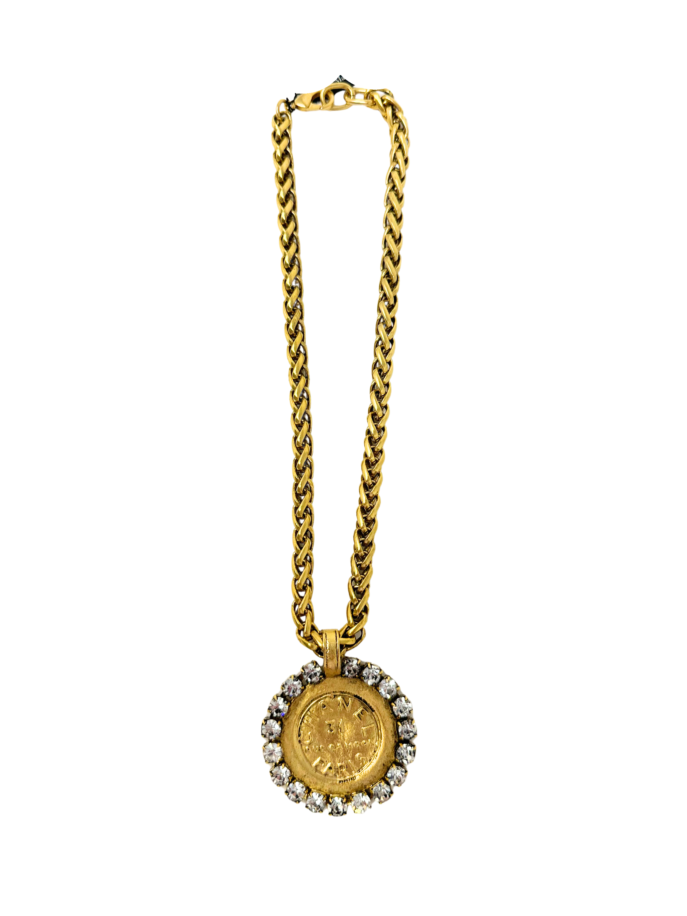 Gold chain necklace featuring a large coin pendant surrounded by clear rhinestones.