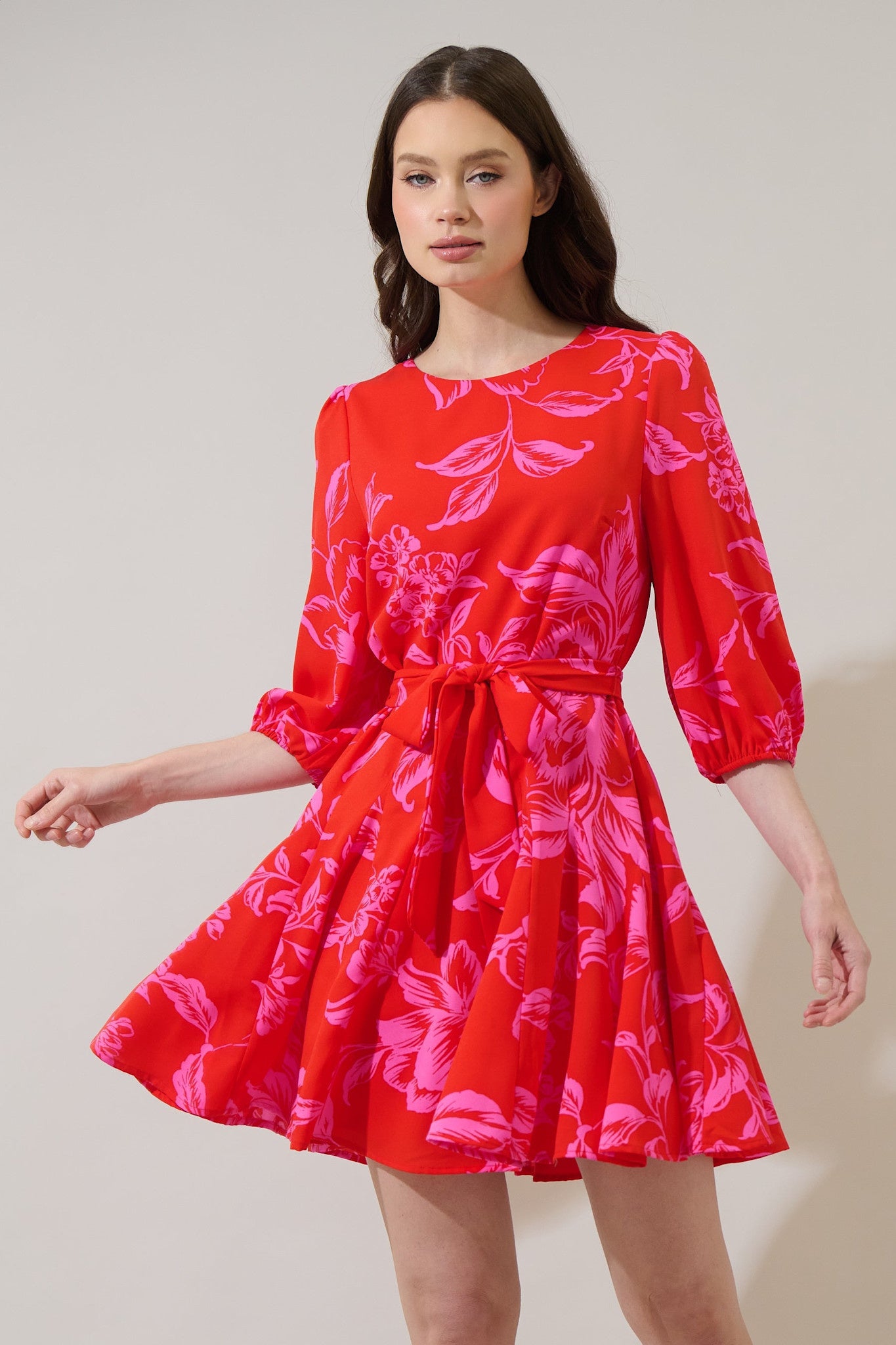Red floral mini dress with balloon sleeves, fit-and-flare godet pleated skirt, and tie waist belt.