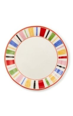 Handmade stoneware dinner plate with a colorful fair-themed pattern featuring horses and wagons on an off-white background.