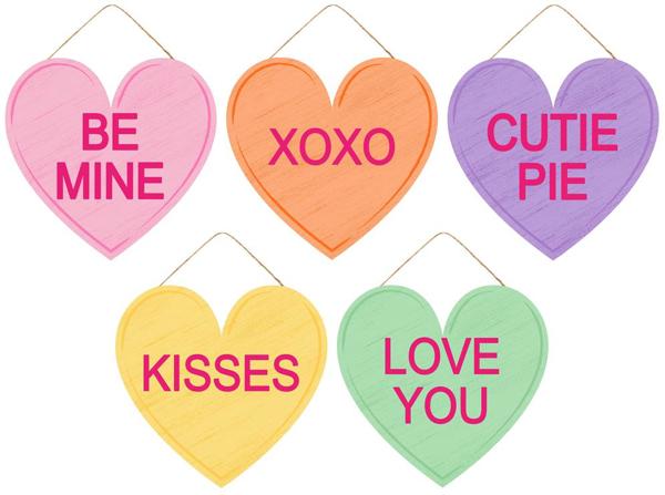 MDF sign shaped like a red heart with white candy hearts pattern.