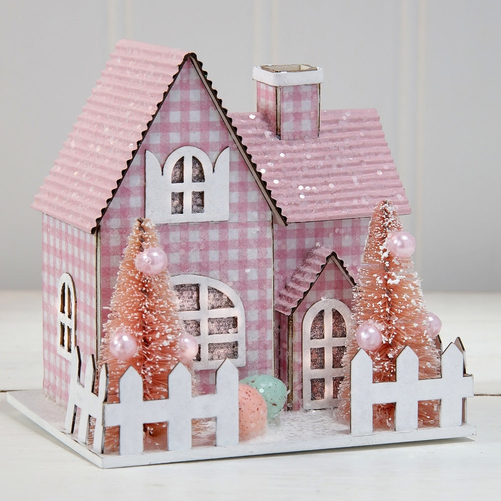 Cardboard Easter house with sugared finish, LED lights, and spring tree patterns.