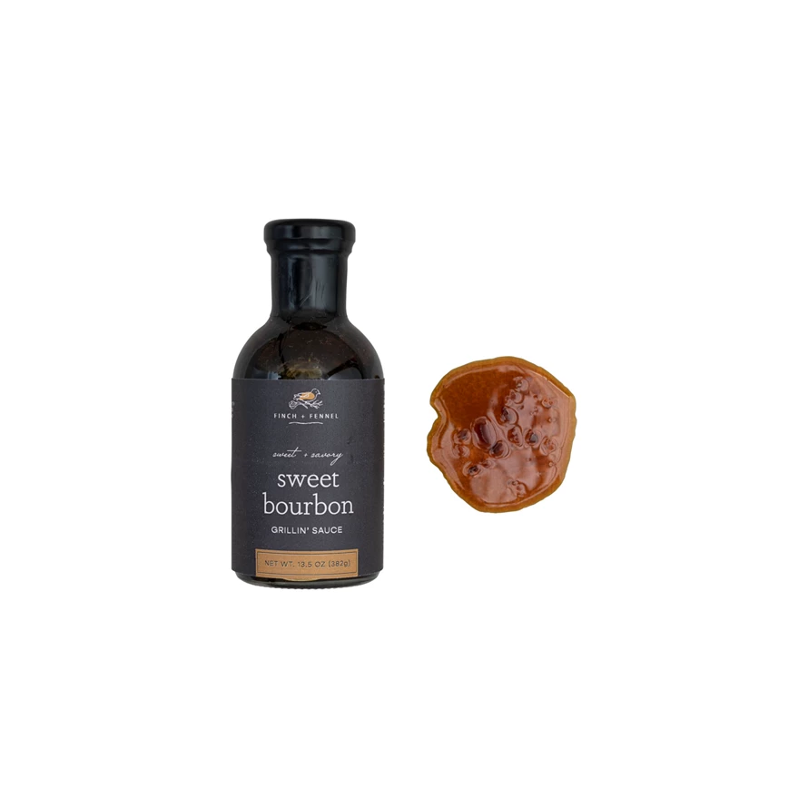 A bottle of Finch + Fennel Sweet Bourbon Grillin' Sauce next to a sample of the brown sauce.