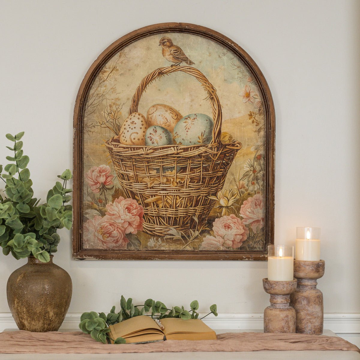Arched framed print showing eggs in a basket with glass front and wood frame