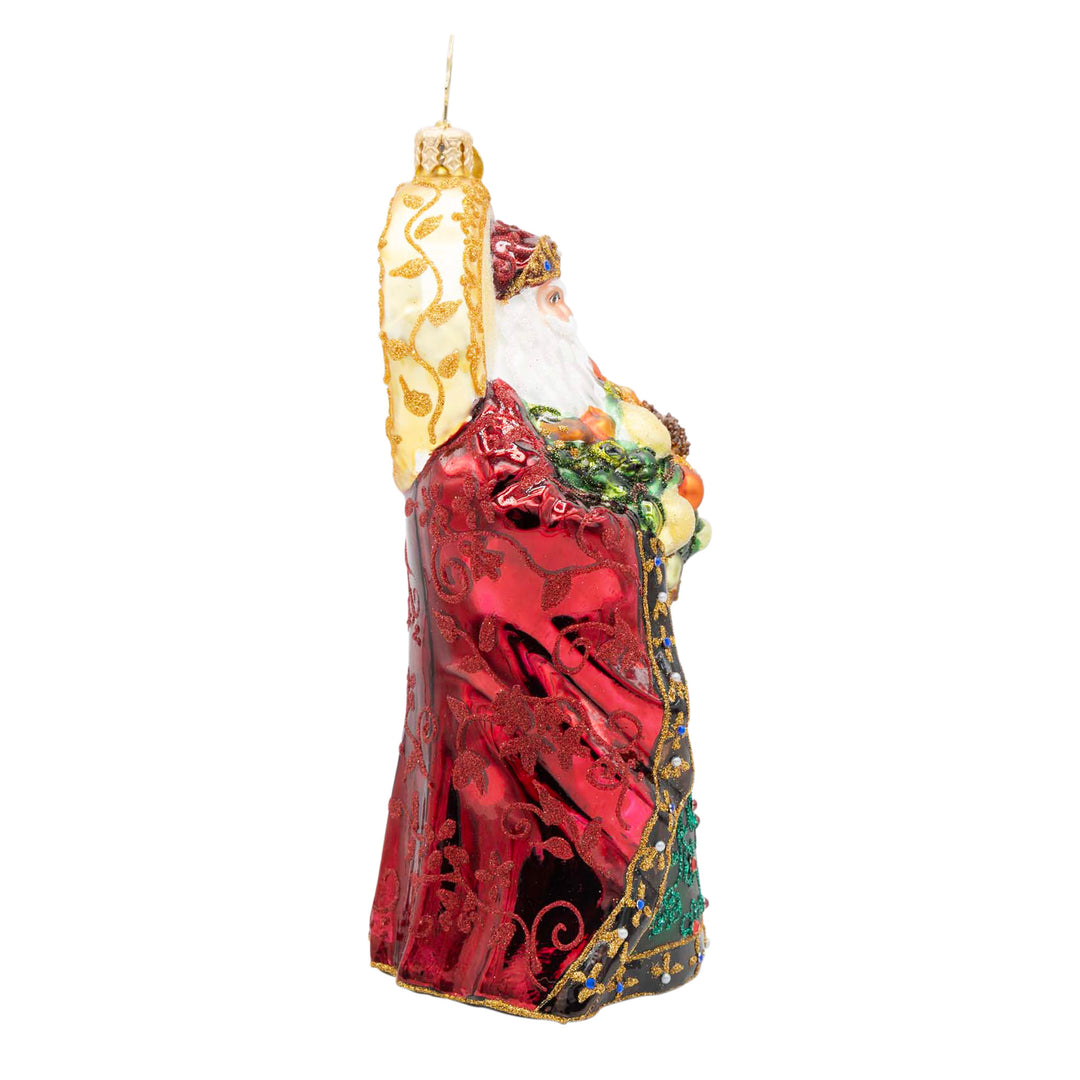 Regal Radiance Santa ornament in a red patterned robe holding a bouquet with gold accents.
