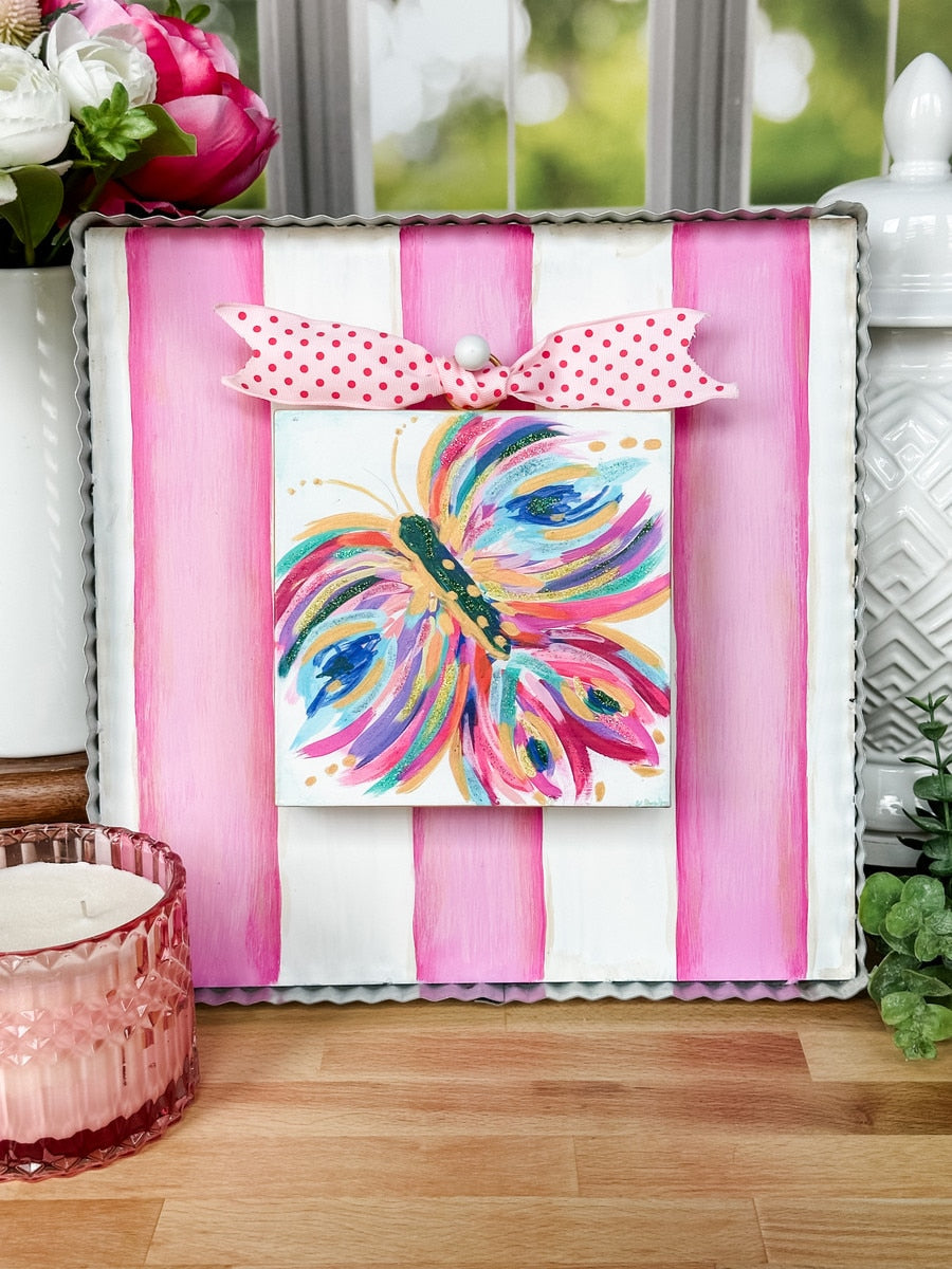 Pink and white display board with a square shape designed to hang on an easel.