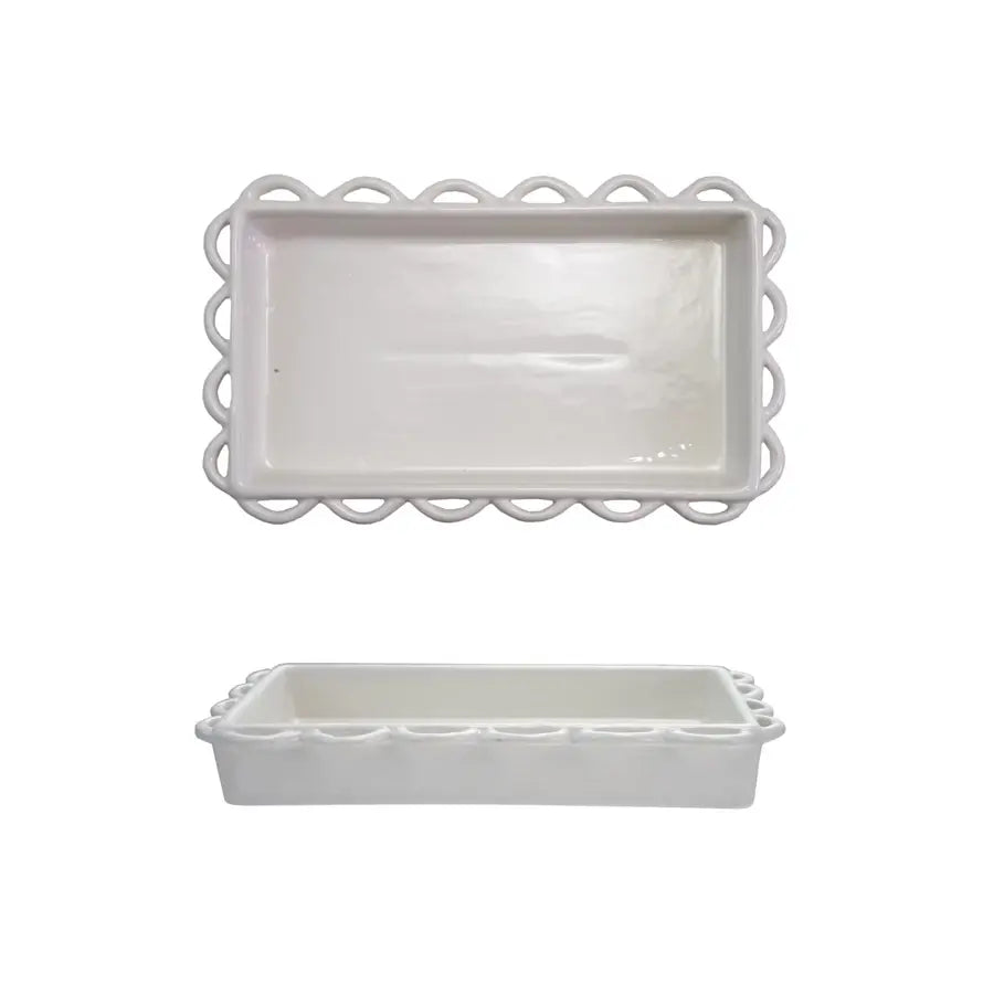 Decorative scalloped napkin holder in white ceramic with a curved silhouette.