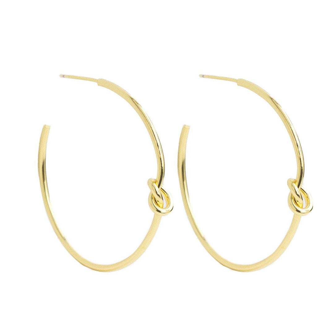 Brass hoop earrings with a delicate knot detail on the front.