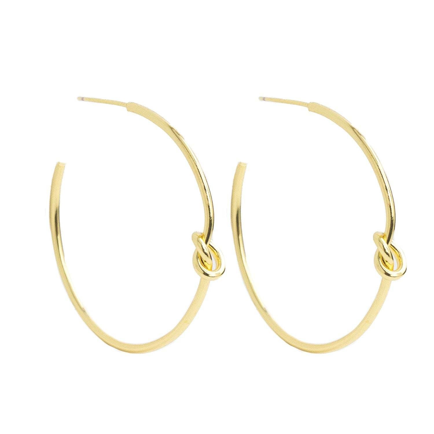 Brass hoop earrings with a delicate knot detail on the front.