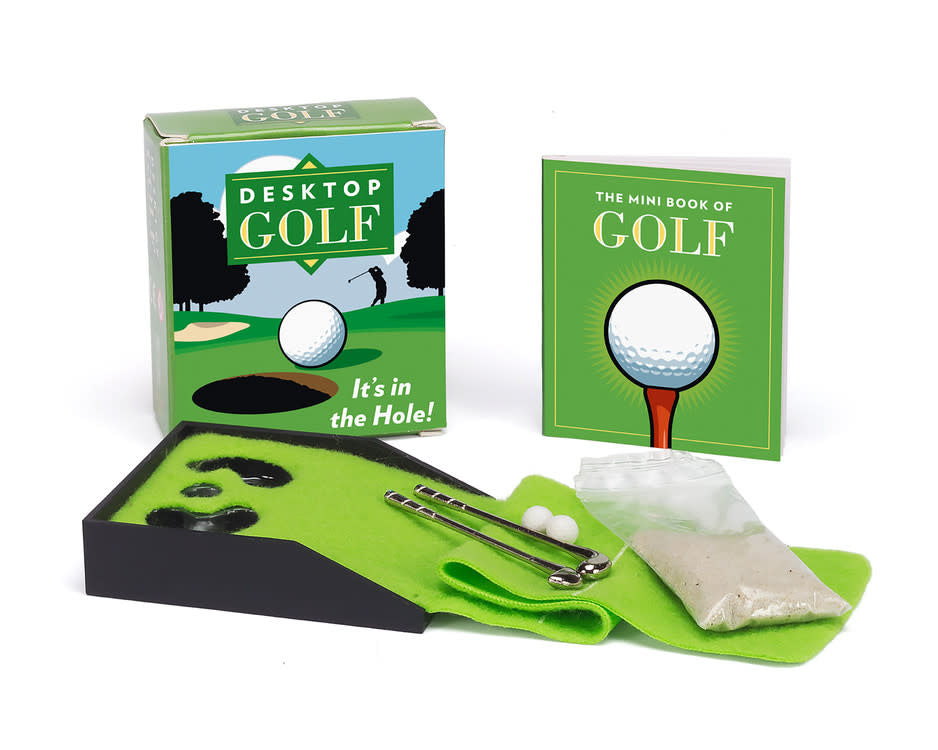 Desktop golf set with mini fairway, two metal clubs, sand packet, and rulebook.