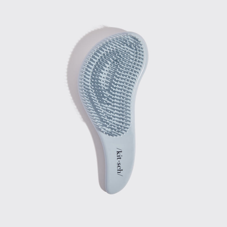 Black detangling brush with flexible bristles designed to smooth tangles.