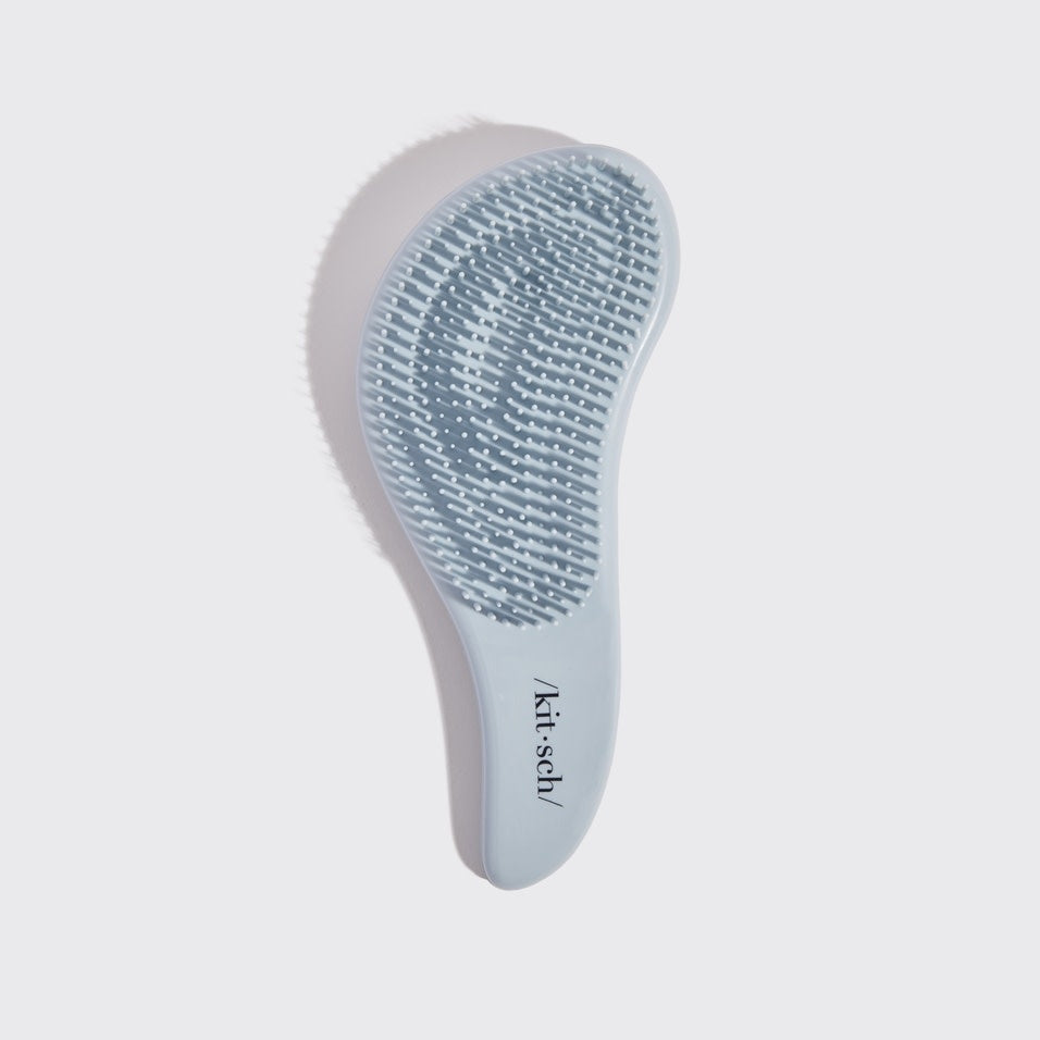 Black detangling brush with flexible bristles designed to smooth tangles.