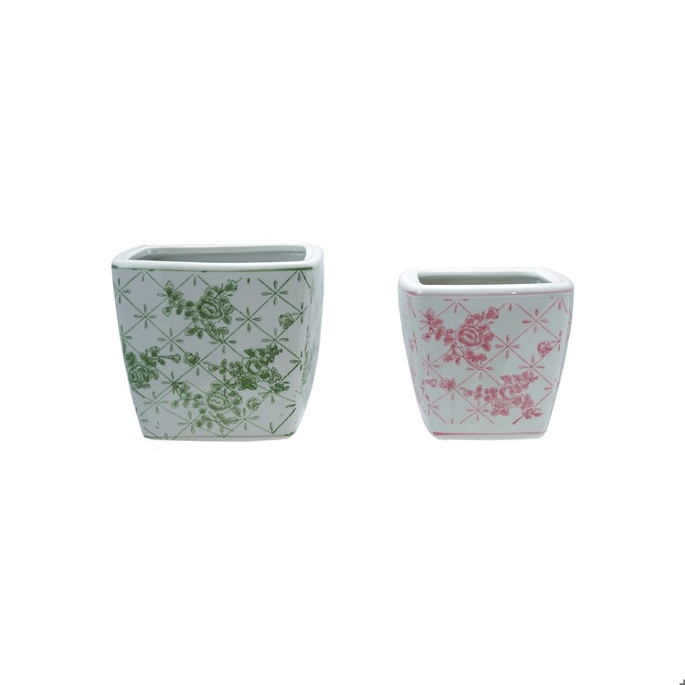 Two square stoneware planters with floral lattice patterns in green and pink.