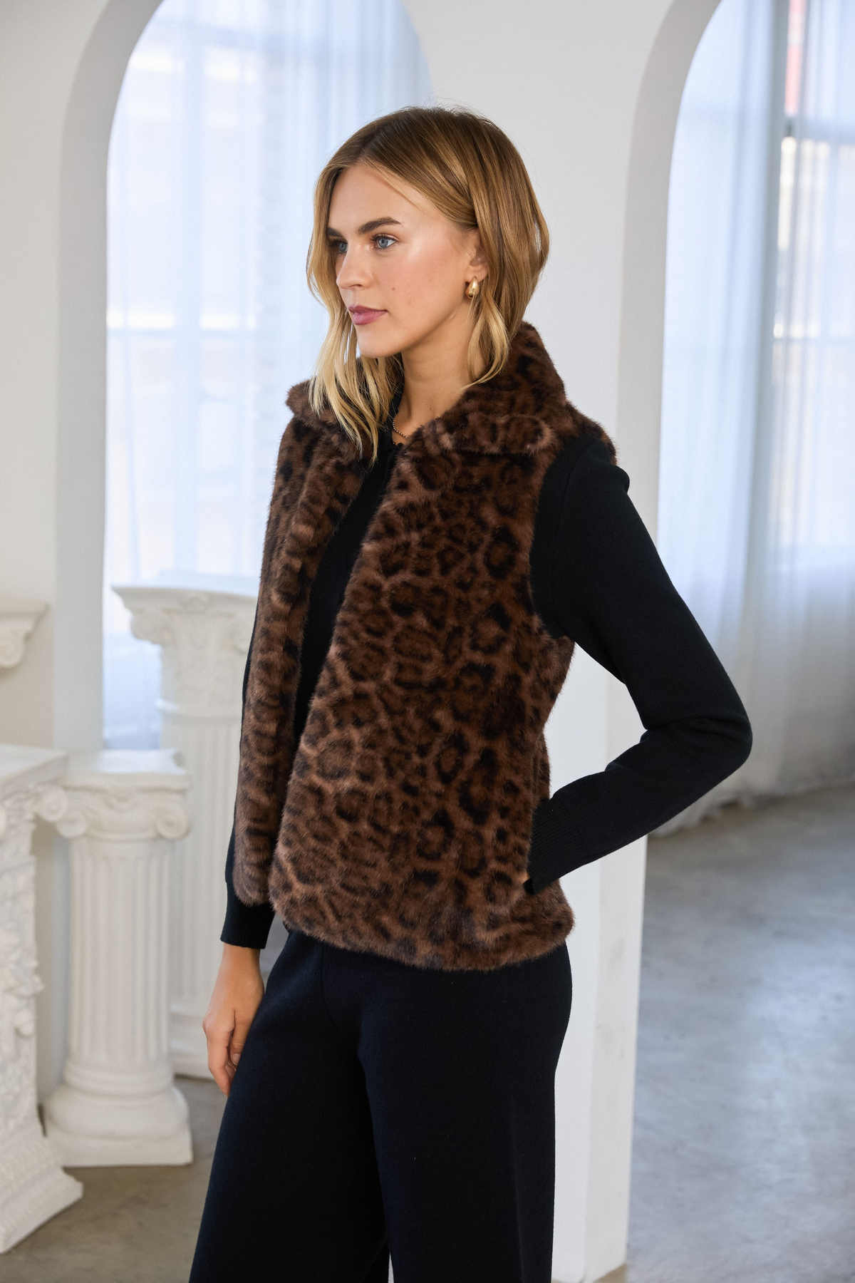 Woman wearing the Celeste Leopard Faux Fur Vest over a black long-sleeve top and matching pants.