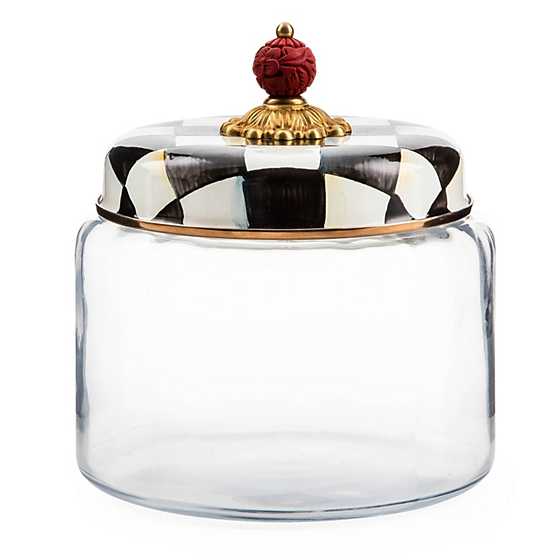 Medium glass kitchen canister with a black and white checkered enamel lid and red cinnabar knob.