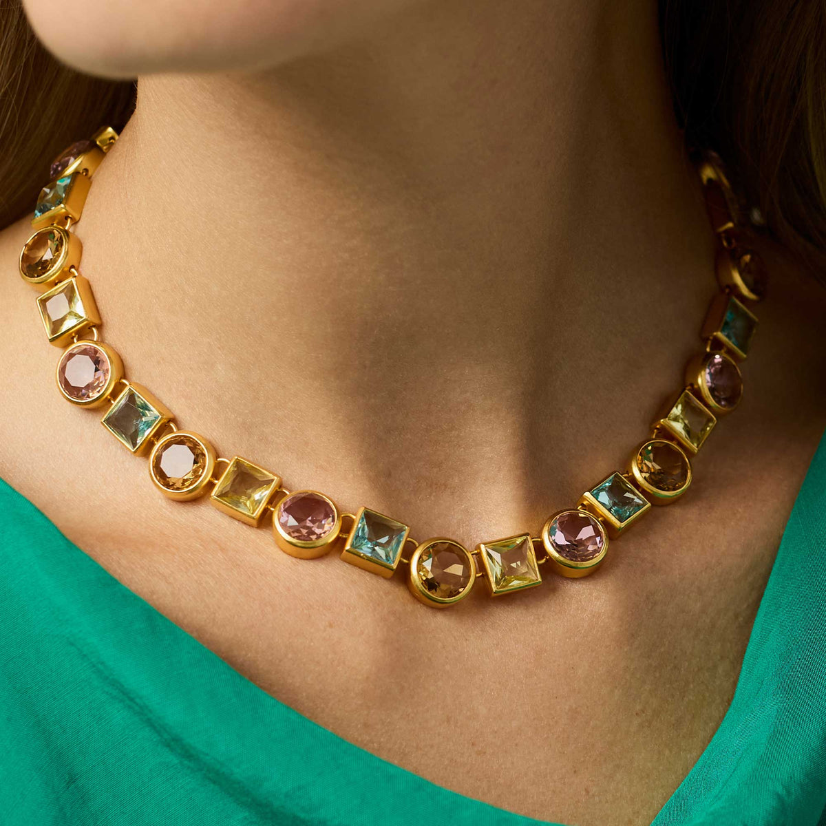 Adjustable tennis necklace with a row of round stones set in gold-plated metal.
