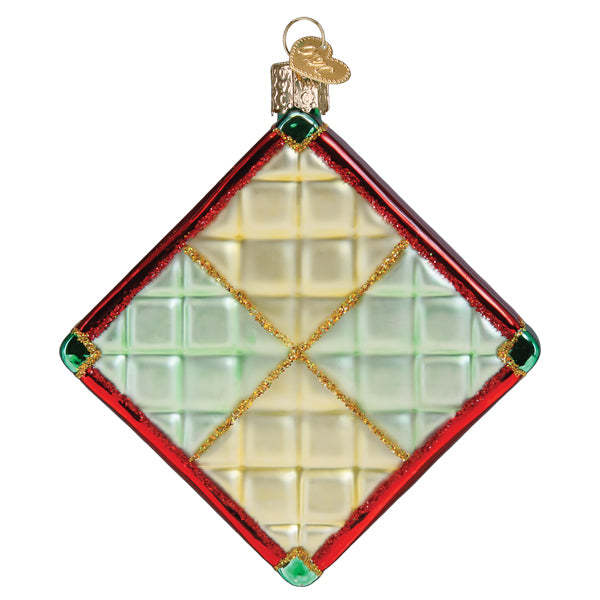 Glass Christmas quilt ornament featuring a patchwork block pattern with red, green, and cream colors.