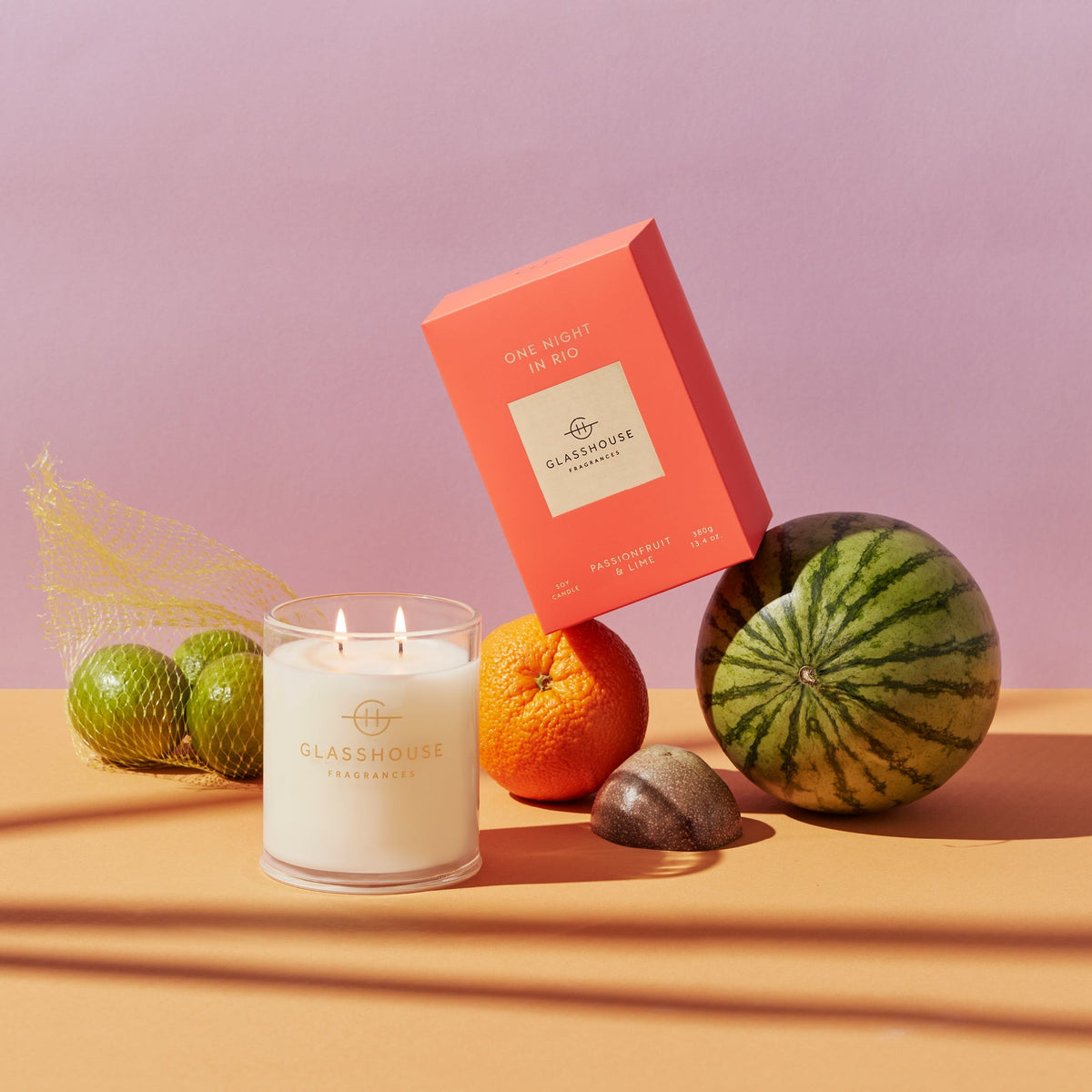One Night In Rio candle in a clear glass jar with vibrant orange wax.