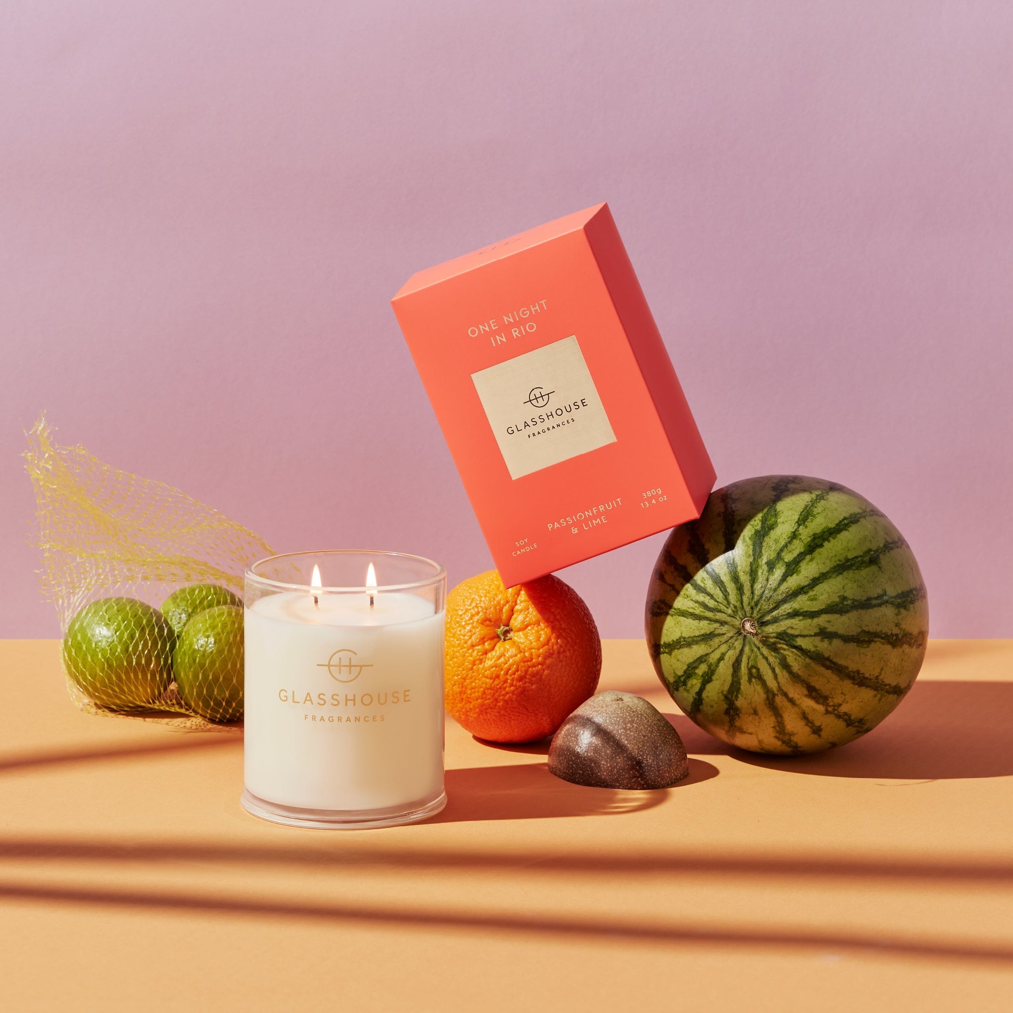 One Night In Rio candle in a clear glass jar with vibrant orange wax.